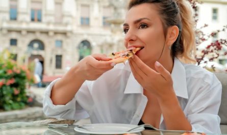 kobieta je pizze w restauracji